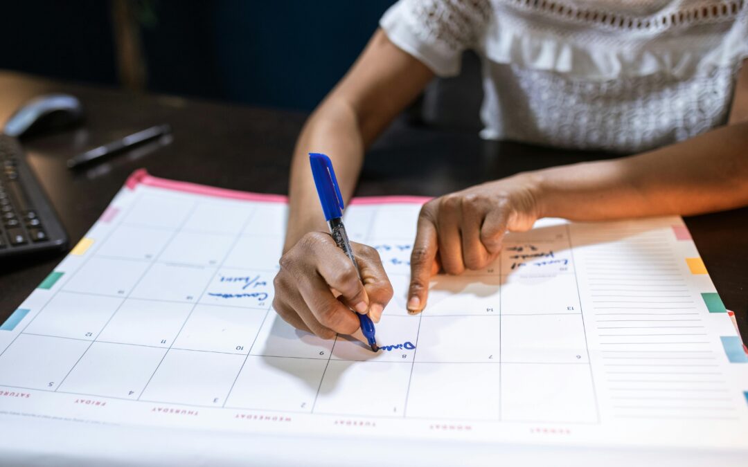 Person planning with marker on a large paper calendar